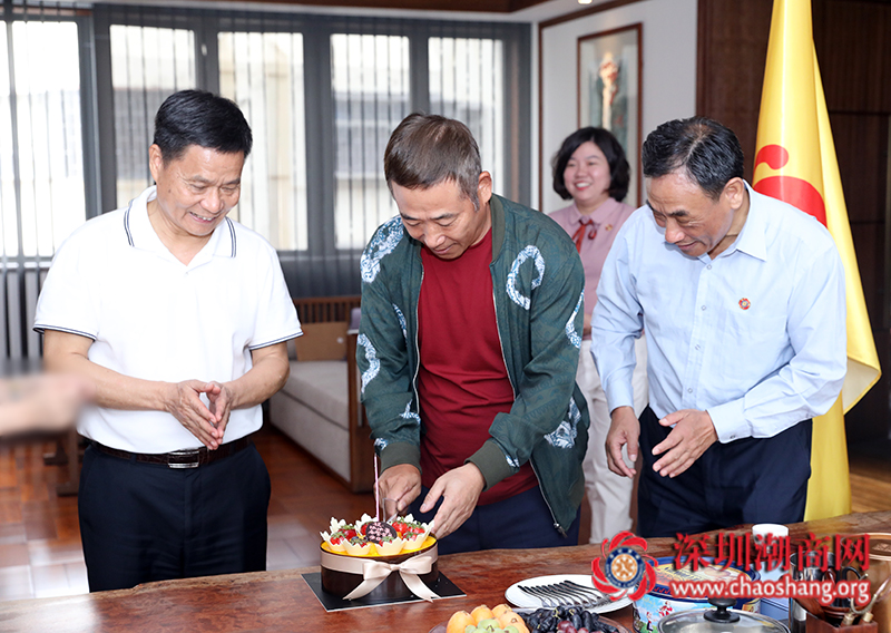 张沐豪名誉会长(中)切蛋糕走访期间,商会向张沐豪名誉会长送上会旗